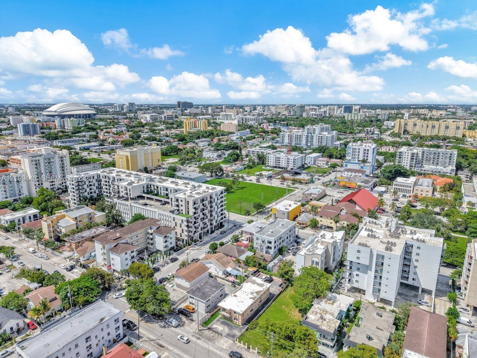 676 SW 1st Street, Miami, FL 33130 Aerial perspective of a high-density urban environment featuring multi-story residential buildings, paved street grids, landscaped green spaces, and surrounding metropolitan infrastructure