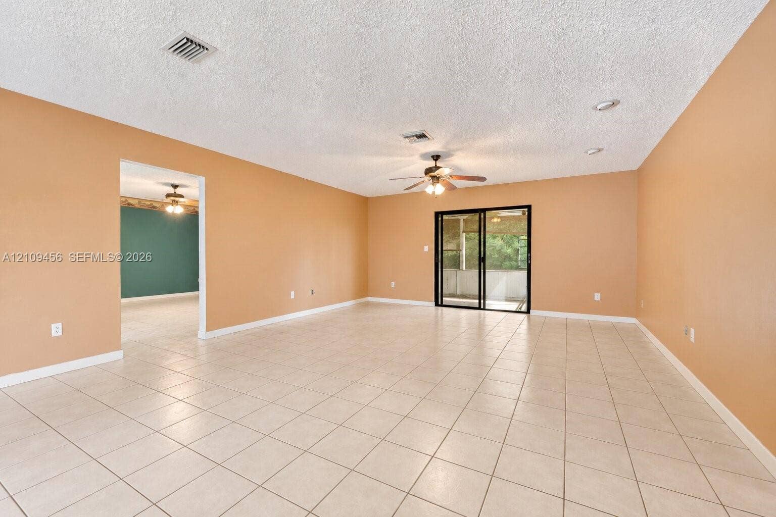 Open-concept space featuring tile flooring, recessed lighting, a ceiling fan, and sliding glass doors