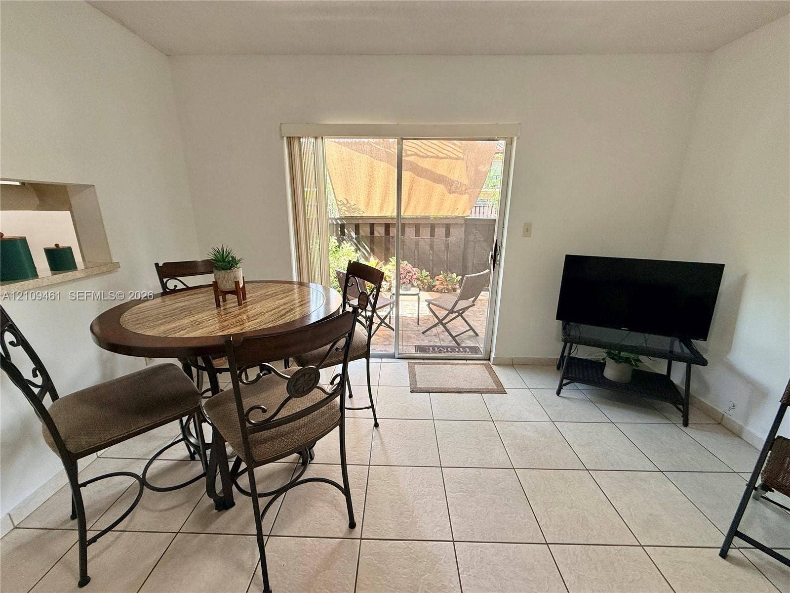 10776 N Kendall Drive, #F11, Miami, FL 33176 Ceramic tile flooring, aluminum-framed sliding glass door, and interior wall cutout