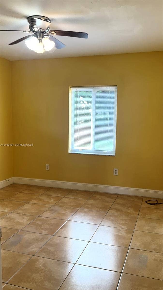Ceramic tile flooring, multi-pane window with horizontal blinds, and a ceiling-mounted light fixture with three glass globes