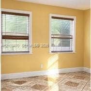 Dual windows with wood-finish blinds and decorative tile flooring