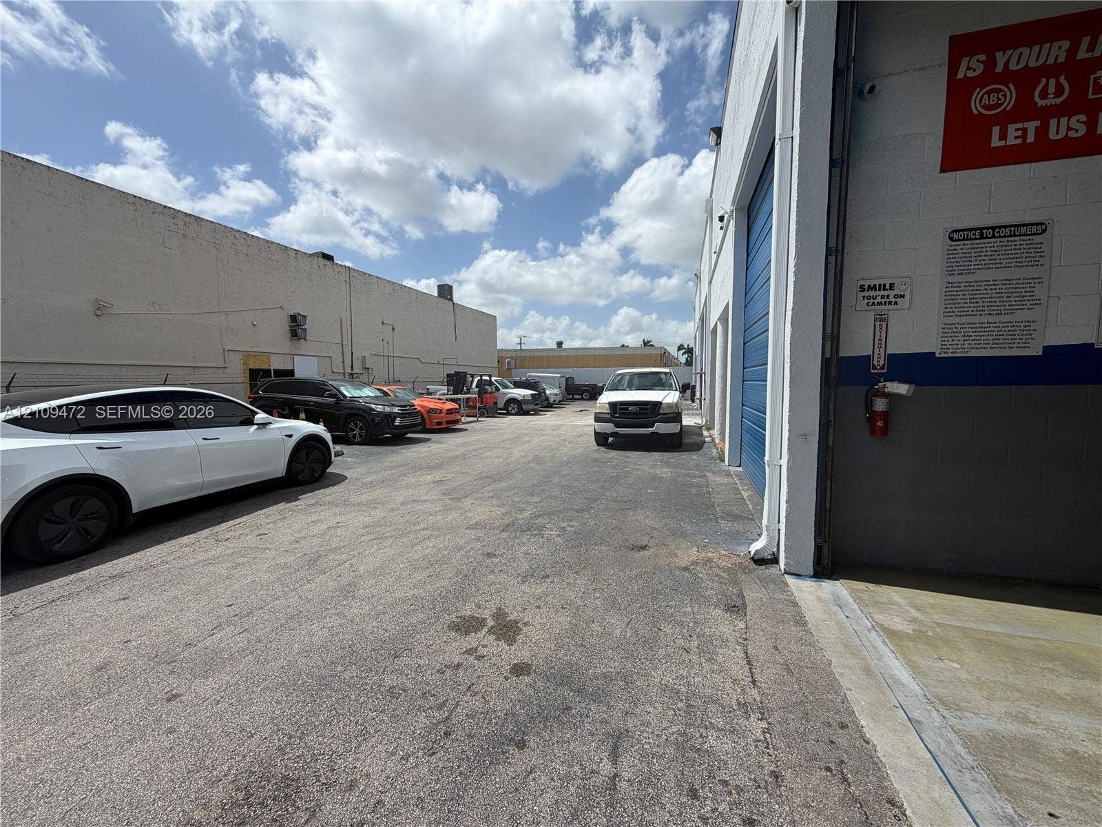 Industrial exterior featuring concrete masonry walls, asphalt paving, and a high-clearance roll-up door