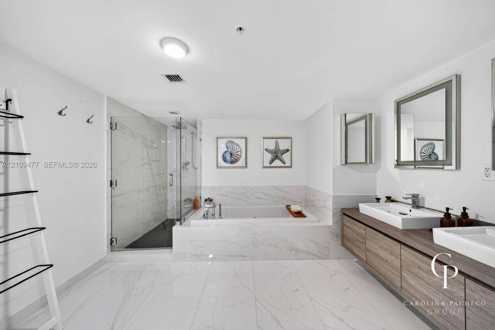 Bathroom featuring a wall-mounted double vanity with wood-finish cabinetry, rectangular vessel sinks, large-format tile flooring, a glass-enclosed walk-in shower, and a built-in soaking tub clad in stone-finish tile