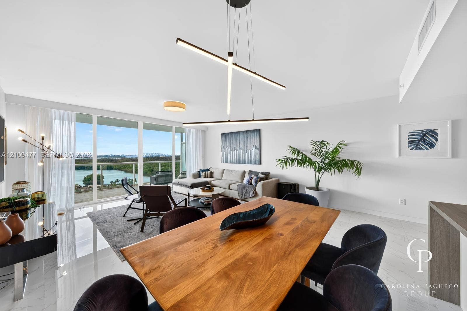 Open-concept space featuring floor-to-ceiling windows, white polished tile flooring, contemporary linear LED pendant lighting, and a glass-railed balcony