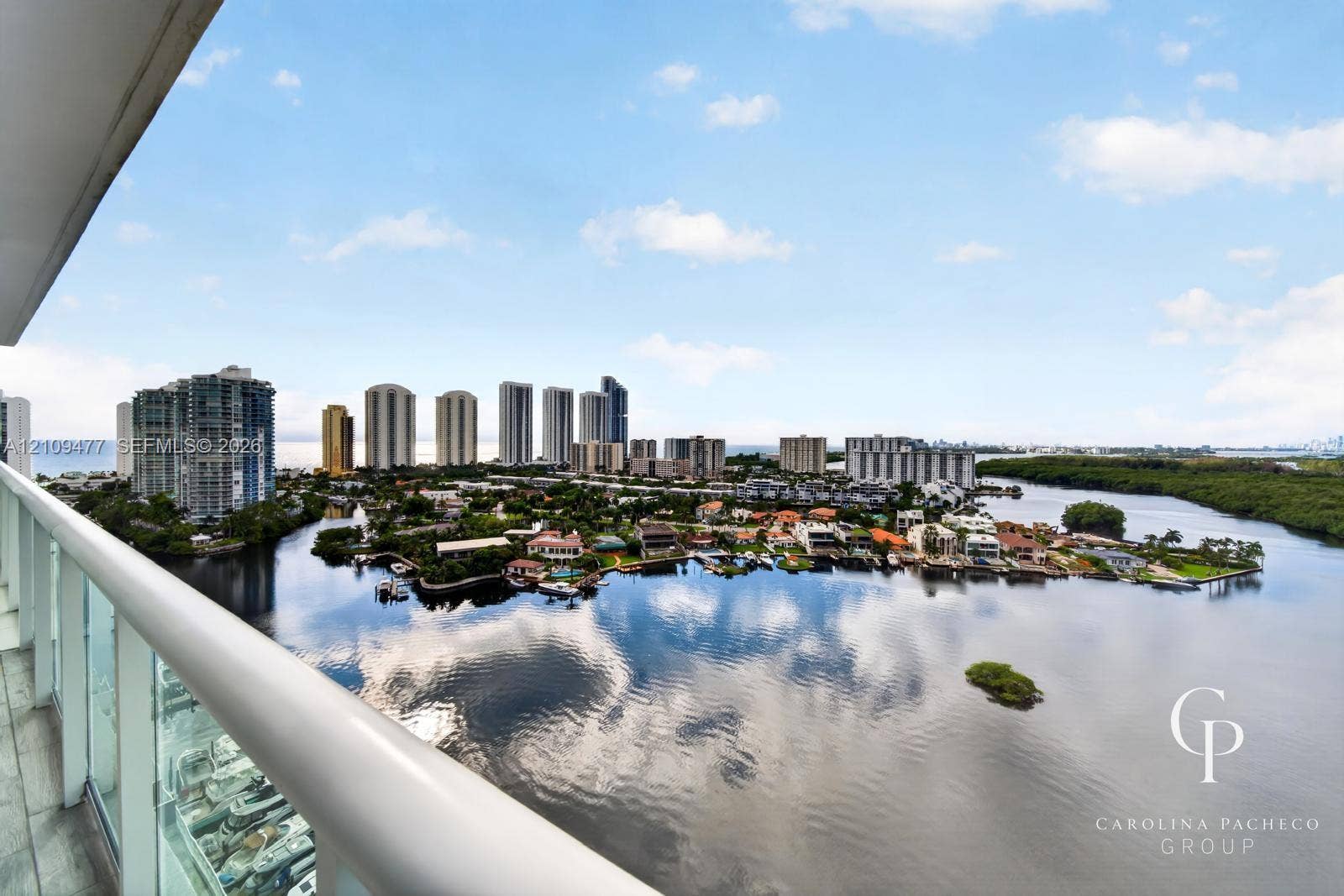 Private balcony featuring glass railings and tile flooring, offering expansive water and cityscape scenery