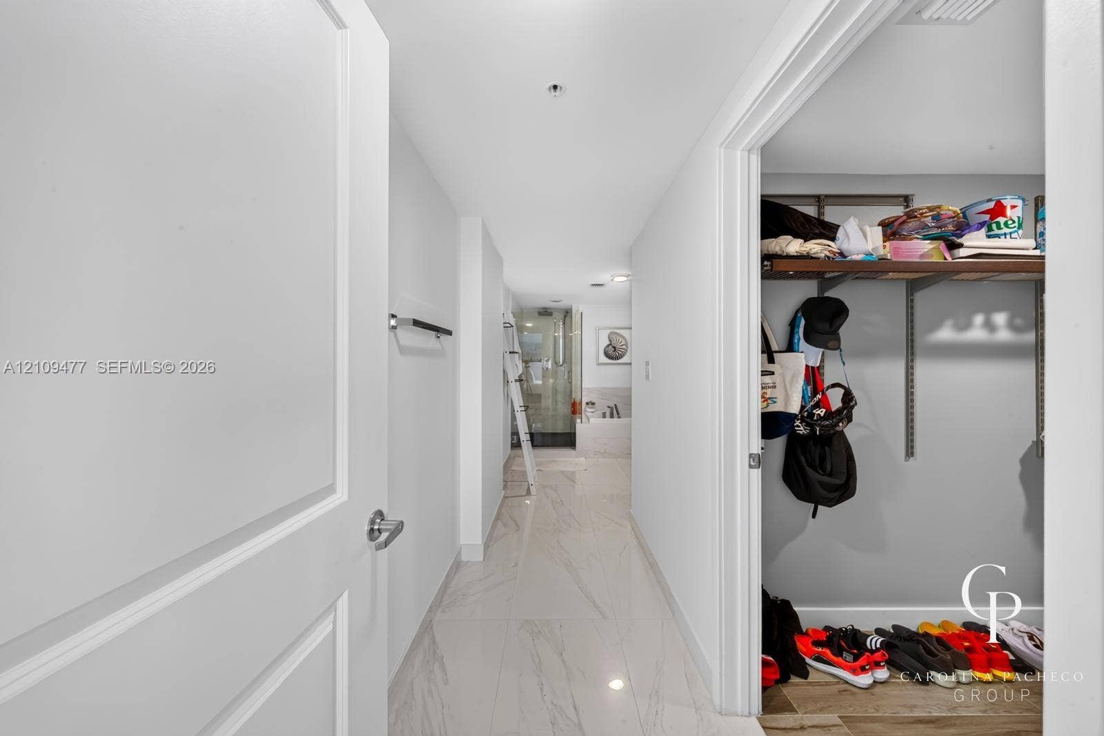 Large-format tile flooring, walk-in closet with adjustable wire shelving, and recessed ceiling lighting