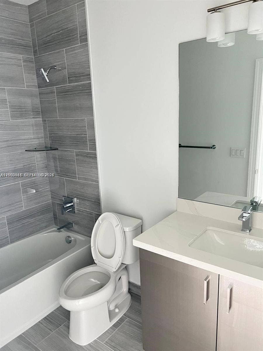 Bathroom featuring a vanity with a light-toned countertop, rectangular undermount sink, and chrome-finish hardware
