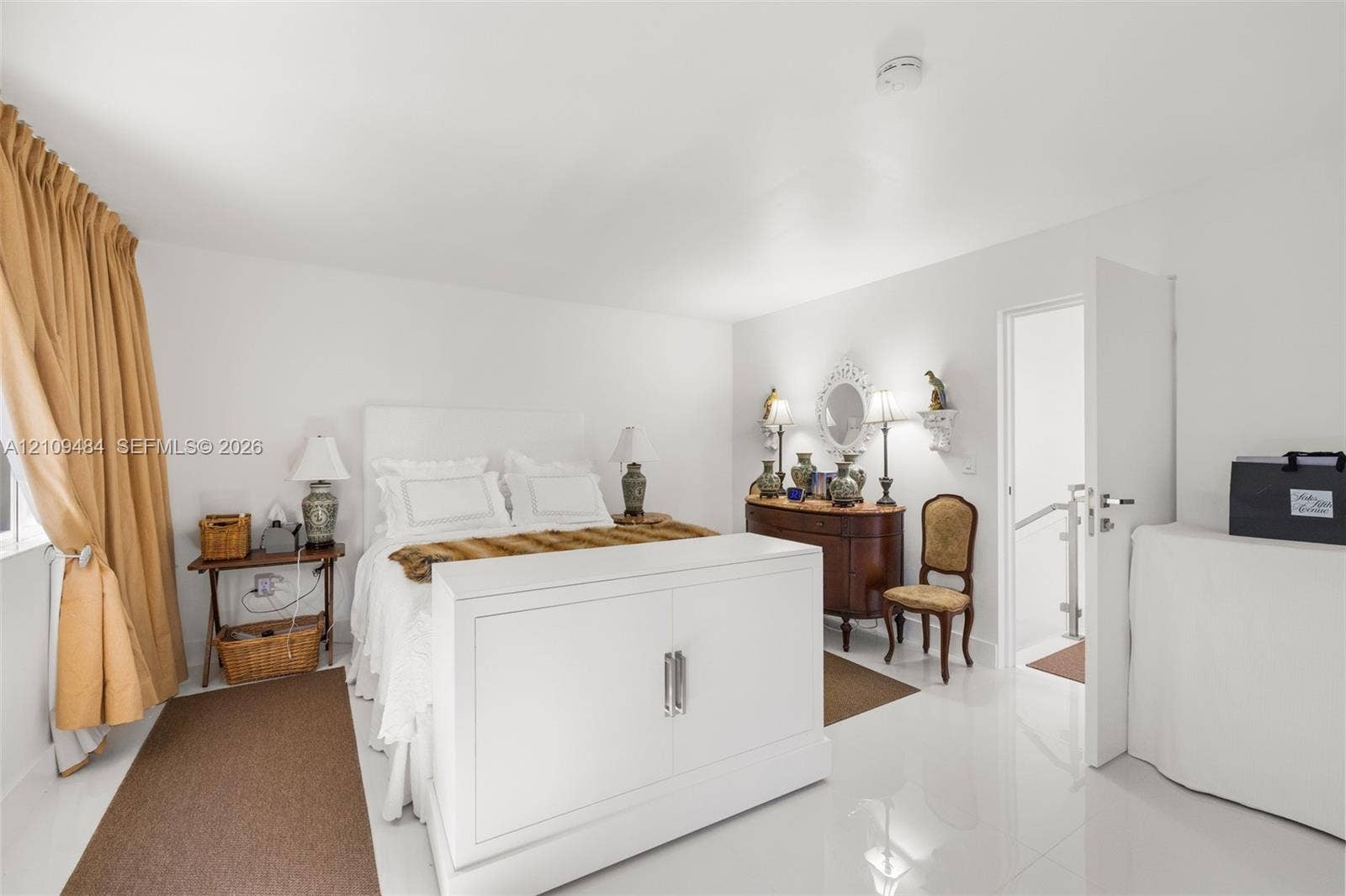Bedroom featuring polished tile flooring, smooth ceiling finish, and an interior door with metal hardware