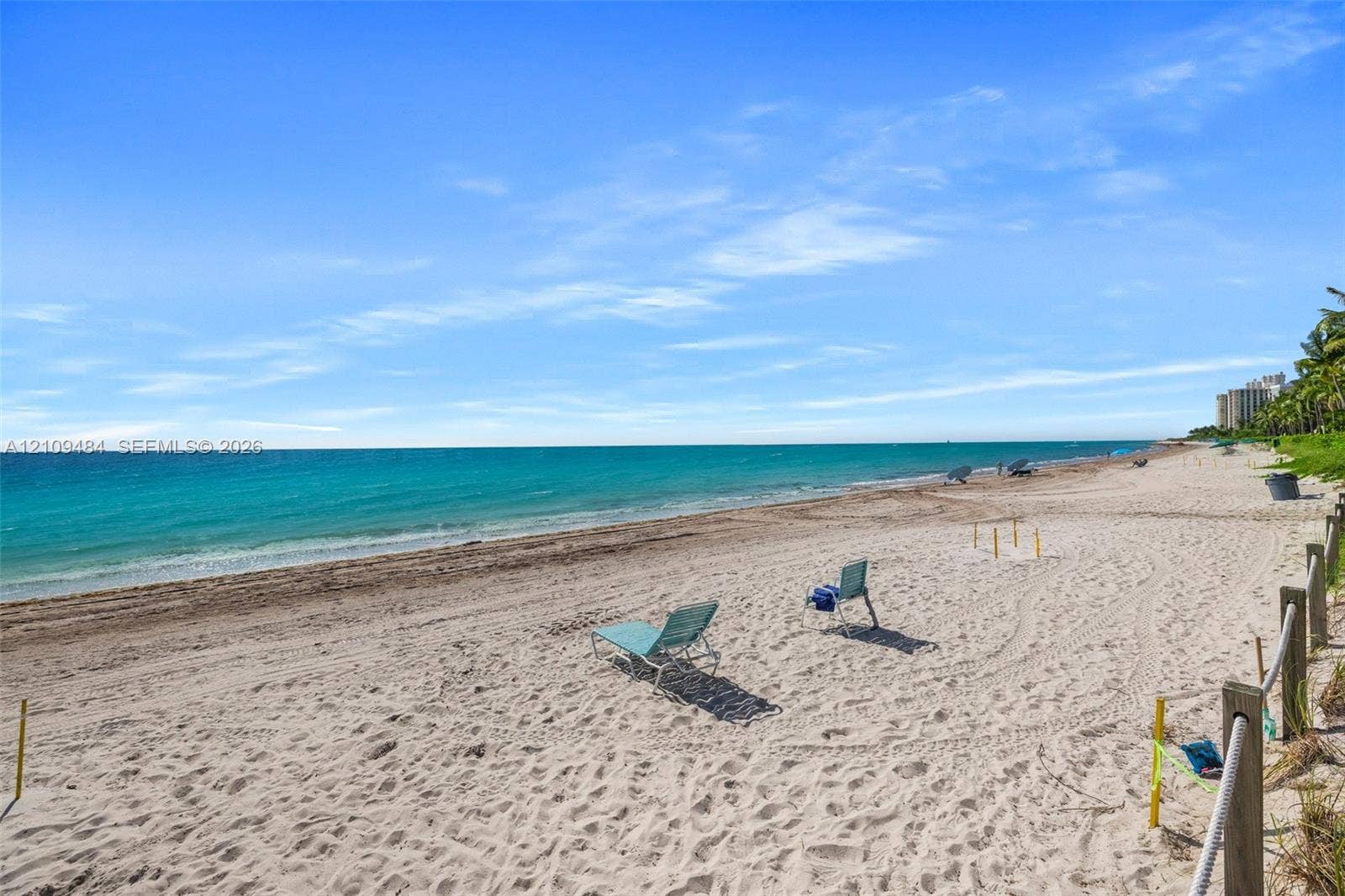 Sandy beachfront property featuring a perimeter wood post and rope boundary fence