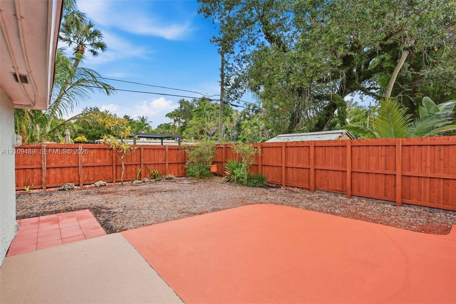 Fort Lauderdale, FL 33312 Fenced backyard featuring a painted concrete patio, tiled accent area, and mature landscaping