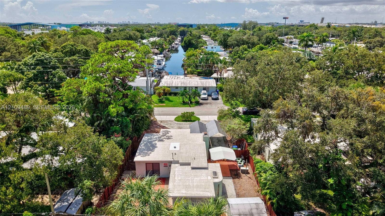 Fort Lauderdale, FL 33312 Aerial perspective of property featuring a flat roofline, paved driveway, enclosed rear outdoor area, and mature landscaping
