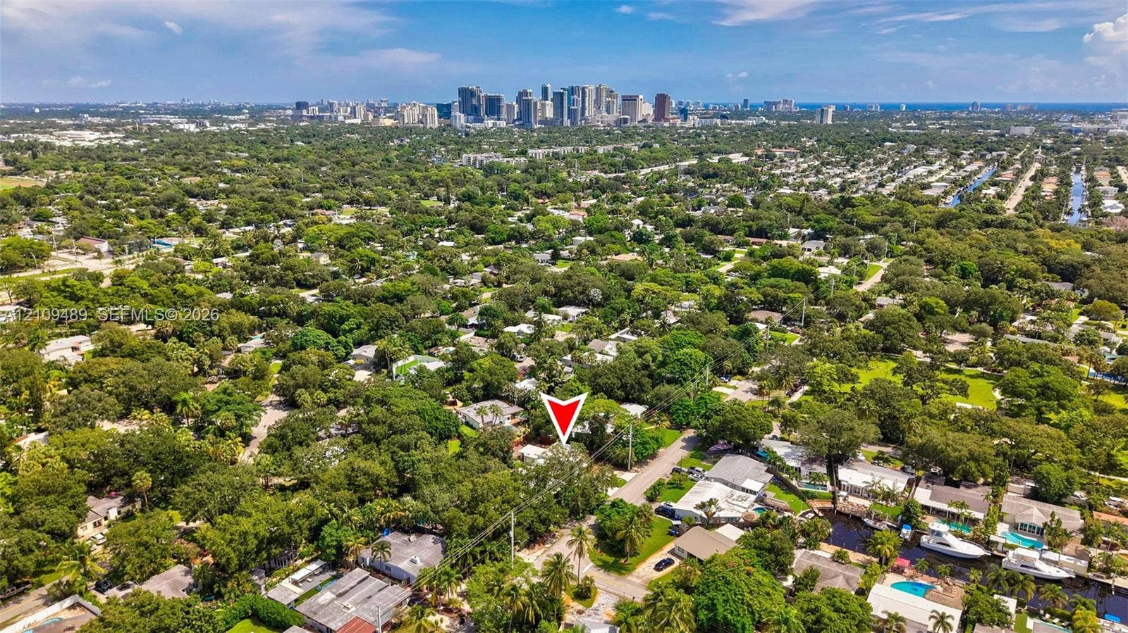 Fort Lauderdale, FL 33312 Aerial perspective featuring mature tree canopy, dense residential landscaping, and a distant cityscape skyline