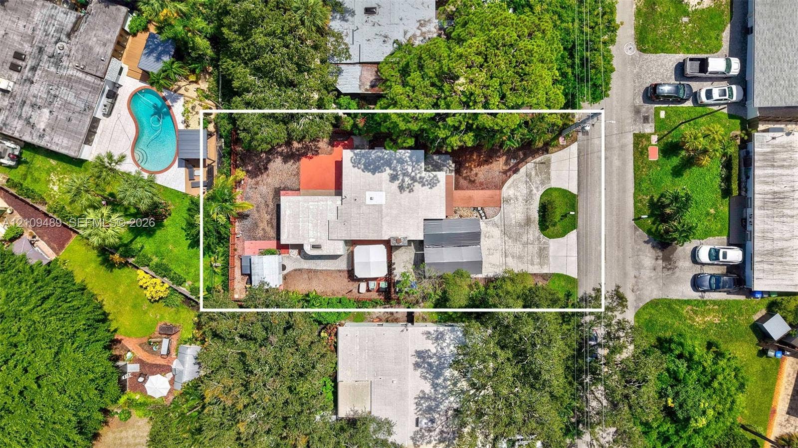 Fort Lauderdale, FL 33312 Aerial perspective of a property featuring a multi-section roofline, paved driveway, dedicated parking area, and mature landscaping