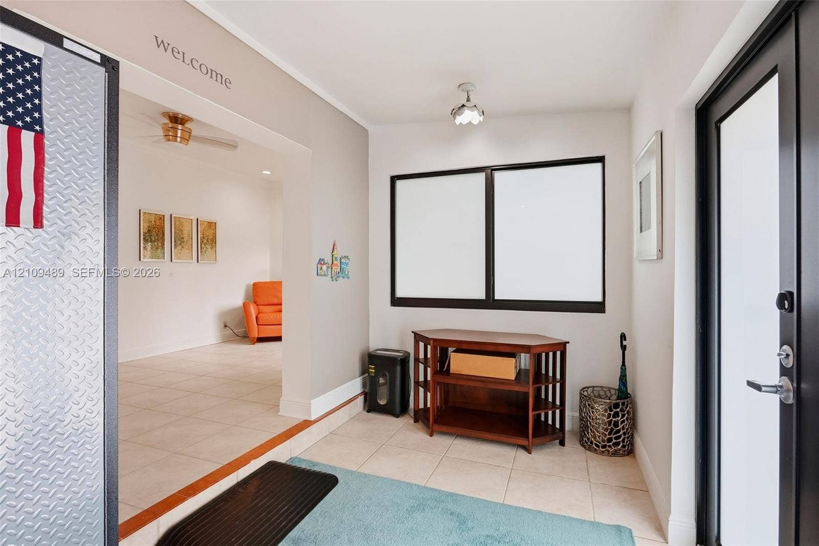 Fort Lauderdale, FL 33312 Entryway featuring large-format tile flooring, dual-pane windows with dark frames, and a glass-inset exterior door with metallic hardware