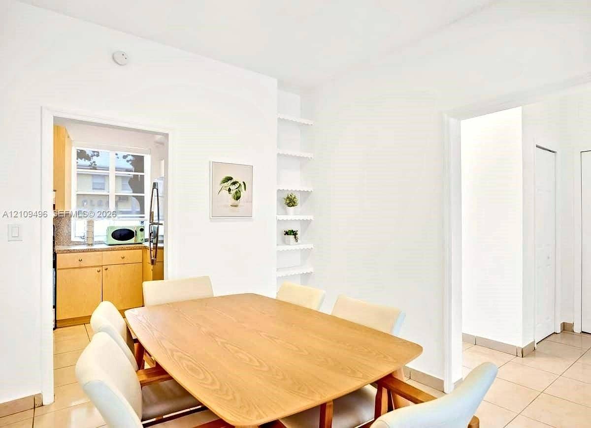 Interior space featuring tile flooring, built-in recessed shelving, and a double-door closet