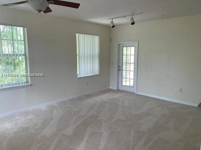 6804 W Sample Road, #6804, Coral Springs, Coral Springs, FL 33067 Neutral interior space featuring carpeting, a multi-light ceiling fan, adjustable track lighting, and a glass-paned exterior door