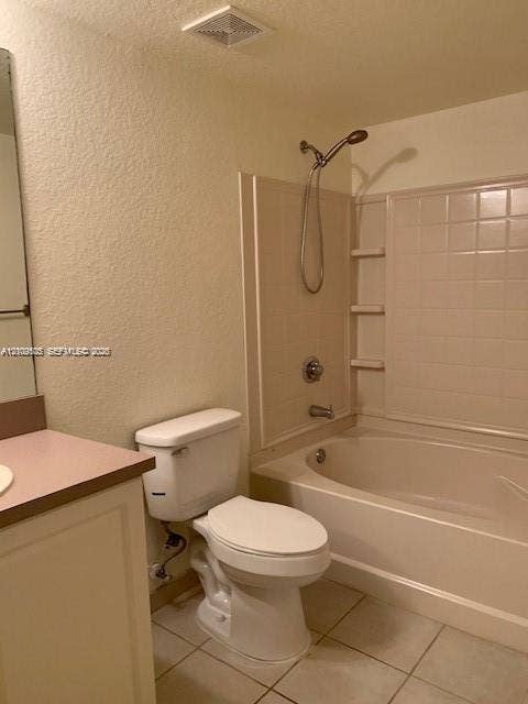 6804 W Sample Road, #6804, Coral Springs, Coral Springs, FL 33067 Bathroom featuring a vanity with a solid-surface countertop, a porcelain toilet, and a combination tub and shower enclosure with integrated shelving and a handheld showerhead