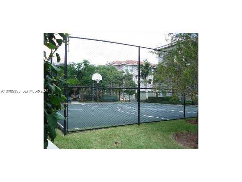 6804 W Sample Road, #6804, Coral Springs, Coral Springs, FL 33067 Fenced sports court featuring a painted hard surface, integrated basketball hoop, and perimeter chain-link enclosure