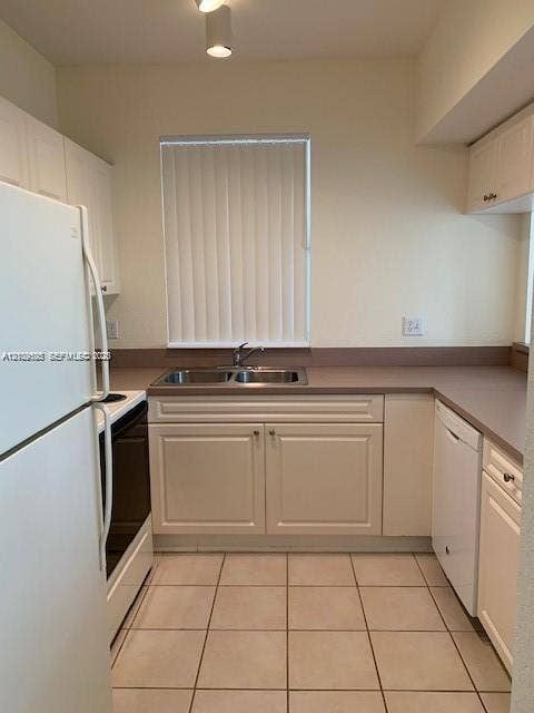 6804 W Sample Road, #6804, Coral Springs, Coral Springs, FL 33067 Kitchen featuring white cabinetry, solid-surface countertops, dual-basin stainless steel sink, tiled flooring, and white appliances