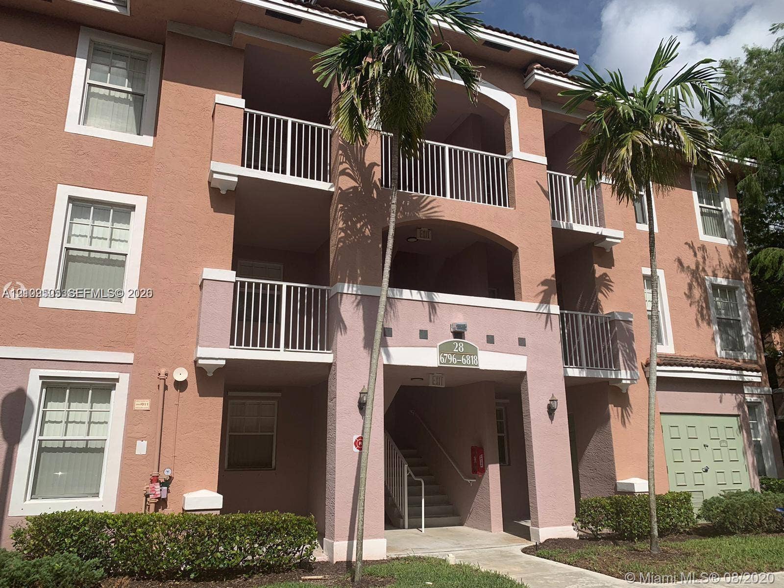6804 W Sample Road, #6804, Coral Springs, Coral Springs, FL 33067 Stucco exterior featuring multi-level balconies with metal railings, arched architectural details, and mature palm landscaping