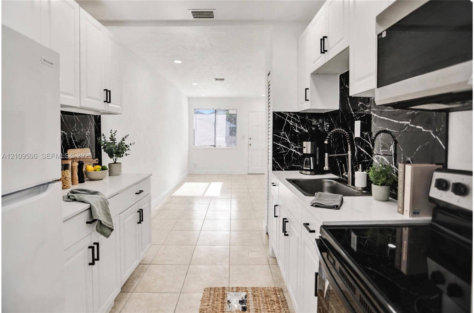 708 N 20th, #1-2, Hollywood, Hollywood, FL 33020 Kitchen featuring white shaker-style cabinetry, solid-surface countertops, high-contrast dark stone-patterned backsplash, undermount sink with arched pull-down faucet, and recessed lighting