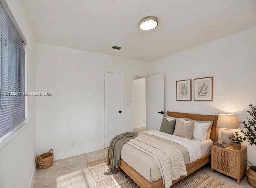 708 N 20th, #1-2, Hollywood, Hollywood, FL 33020 Staged interior space featuring tile flooring, a flush-mount ceiling light fixture, a window with horizontal blinds, and solid-core interior doors with matte black hardware
