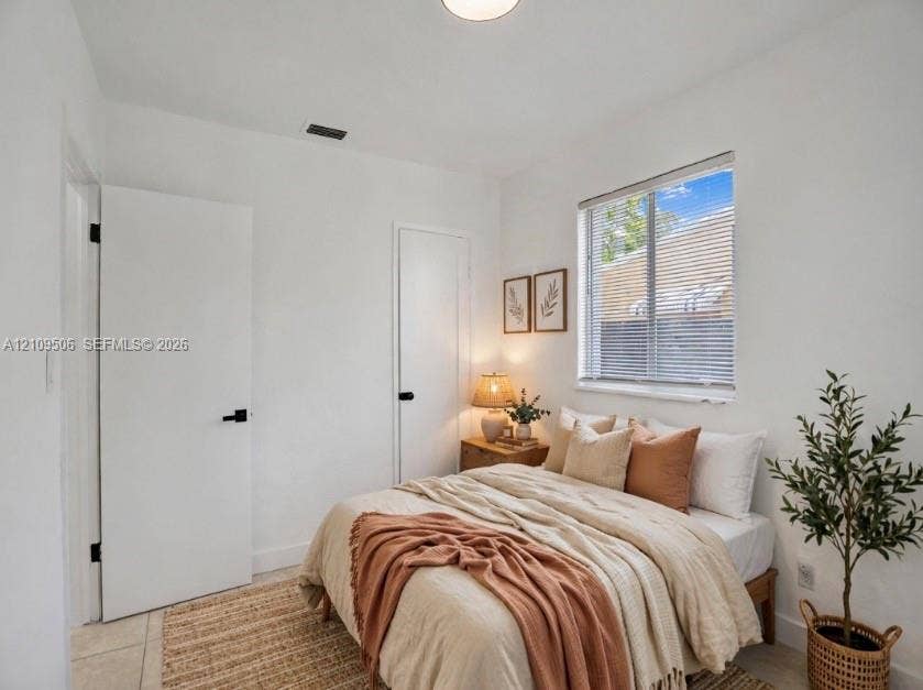 708 N 20th, #1-2, Hollywood, Hollywood, FL 33020 Staged interior featuring white walls, tile flooring, two solid-core doors with matte black hardware, and a single-pane window with horizontal blinds