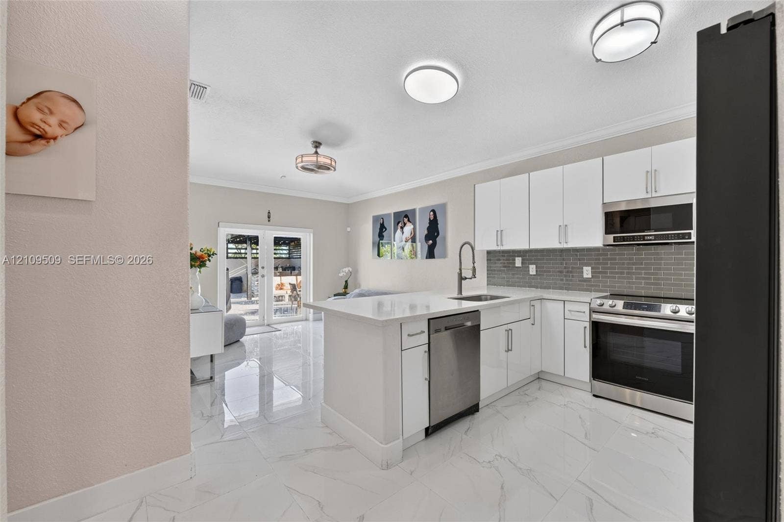 7721 NW 201st Terrace, Hialeah, FL 33015 Kitchen featuring flat-panel white cabinetry, stone-finish countertops, stainless steel appliances, a grey subway tile backsplash, and polished tile flooring
