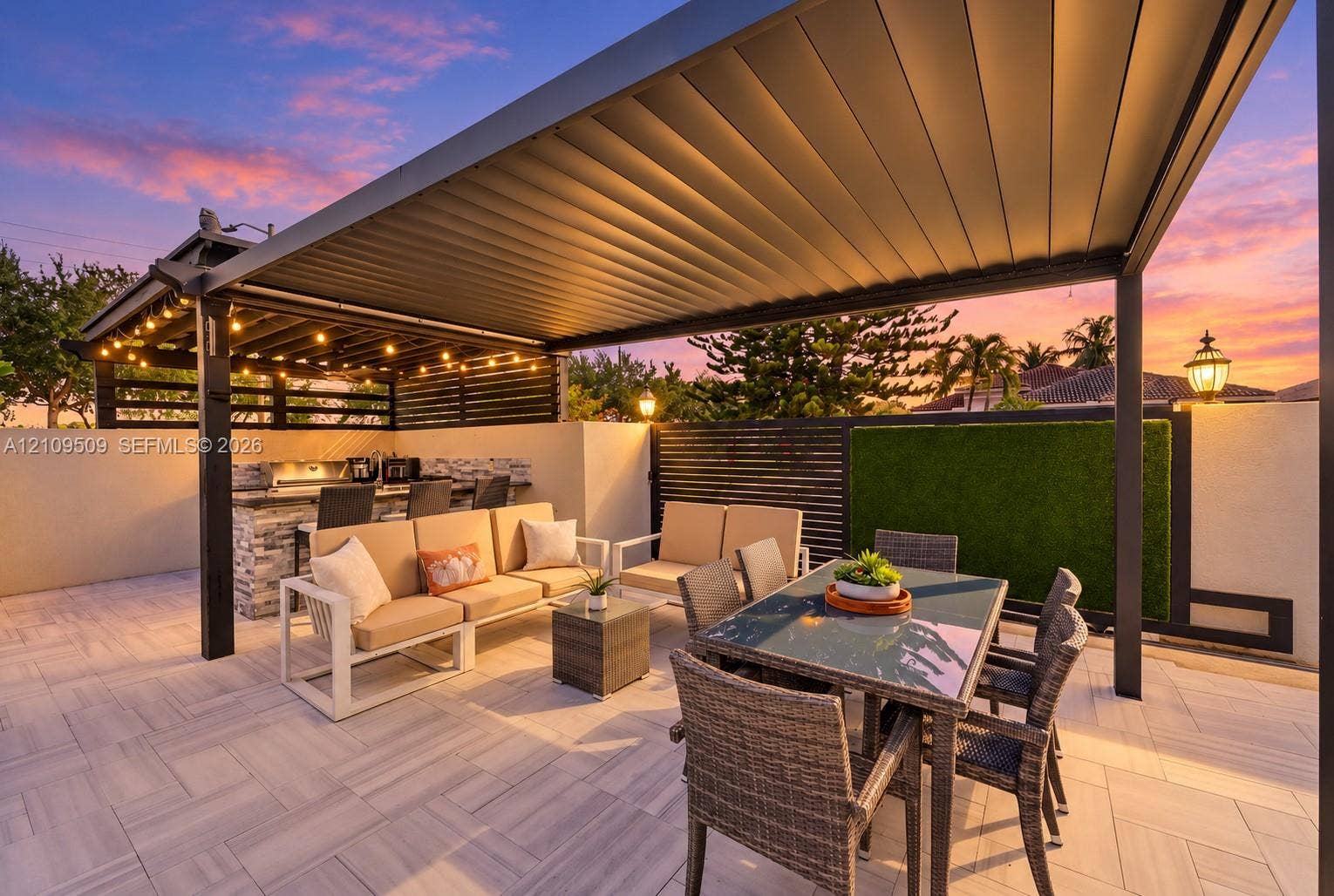 7721 NW 201st Terrace, Hialeah, FL 33015 Outdoor living area featuring a covered pergola, stone-veneer wet bar with built-in grill, herringbone-patterned tile patio, and vertical wall-mounted greenery