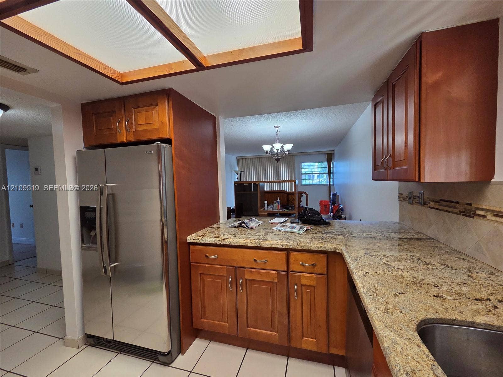 11081 NW 7th Street, #101-14, Miami, FL 33172 Kitchen featuring natural wood cabinetry, stone-surface countertops, stainless steel refrigerator, tile backsplash, and recessed ceiling lighting