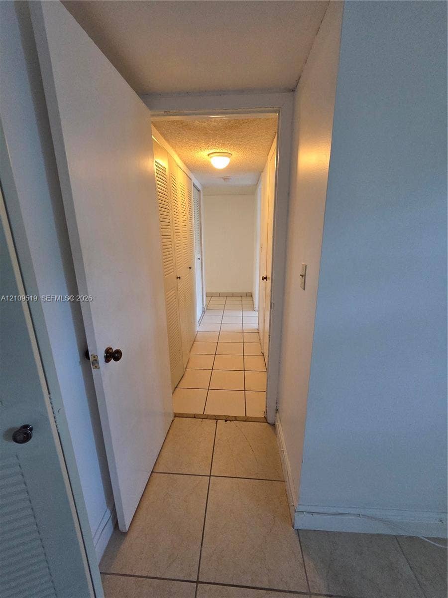 11081 NW 7th Street, #101-14, Miami, FL 33172 Ceramic tile flooring, louvered bi-fold closet doors, and flush-mount ceiling lighting