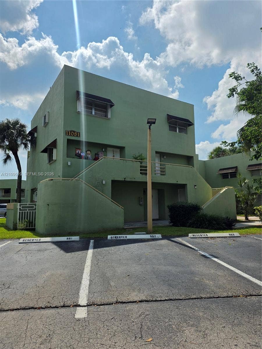 11081 NW 7th Street, #101-14, Miami, FL 33172 Unit encompasses entire ground floor of (3-story building) exterior featuring smooth stucco siding, designated parking spaces, concrete stairways, and protective window awnings