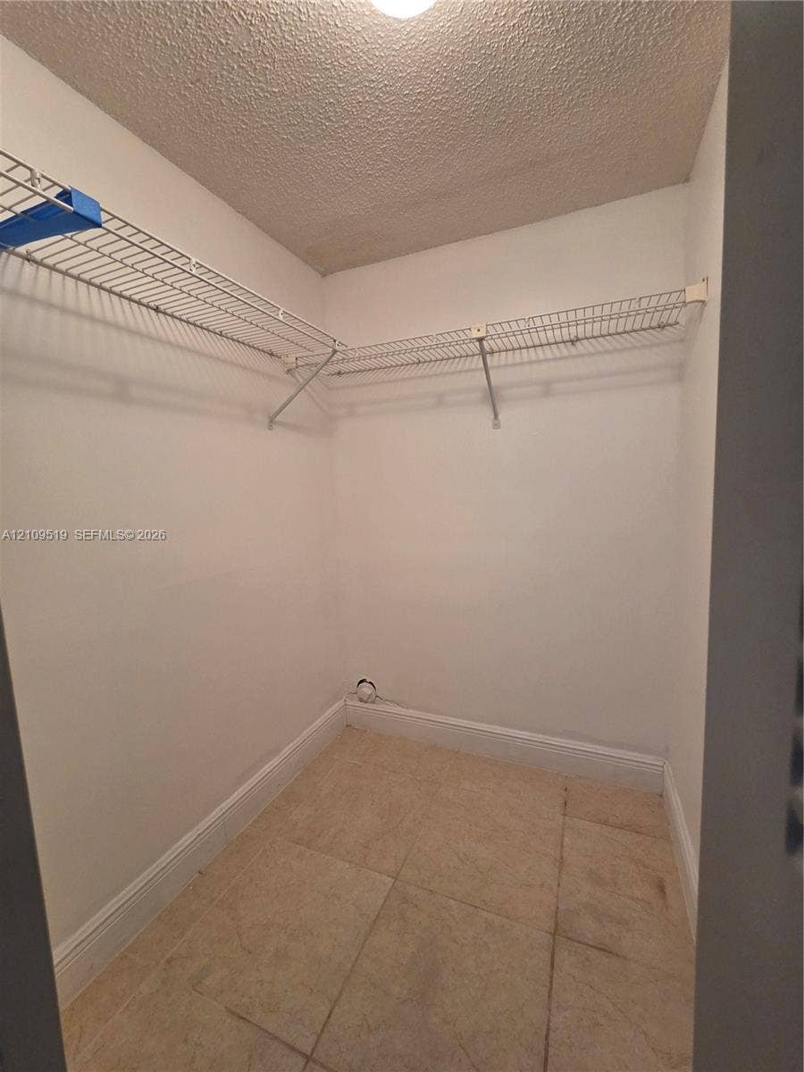 11081 NW 7th Street, #101-14, Miami, FL 33172 Walk-in closet offers generous storage space featuring ceramic tile flooring and white wire shelving