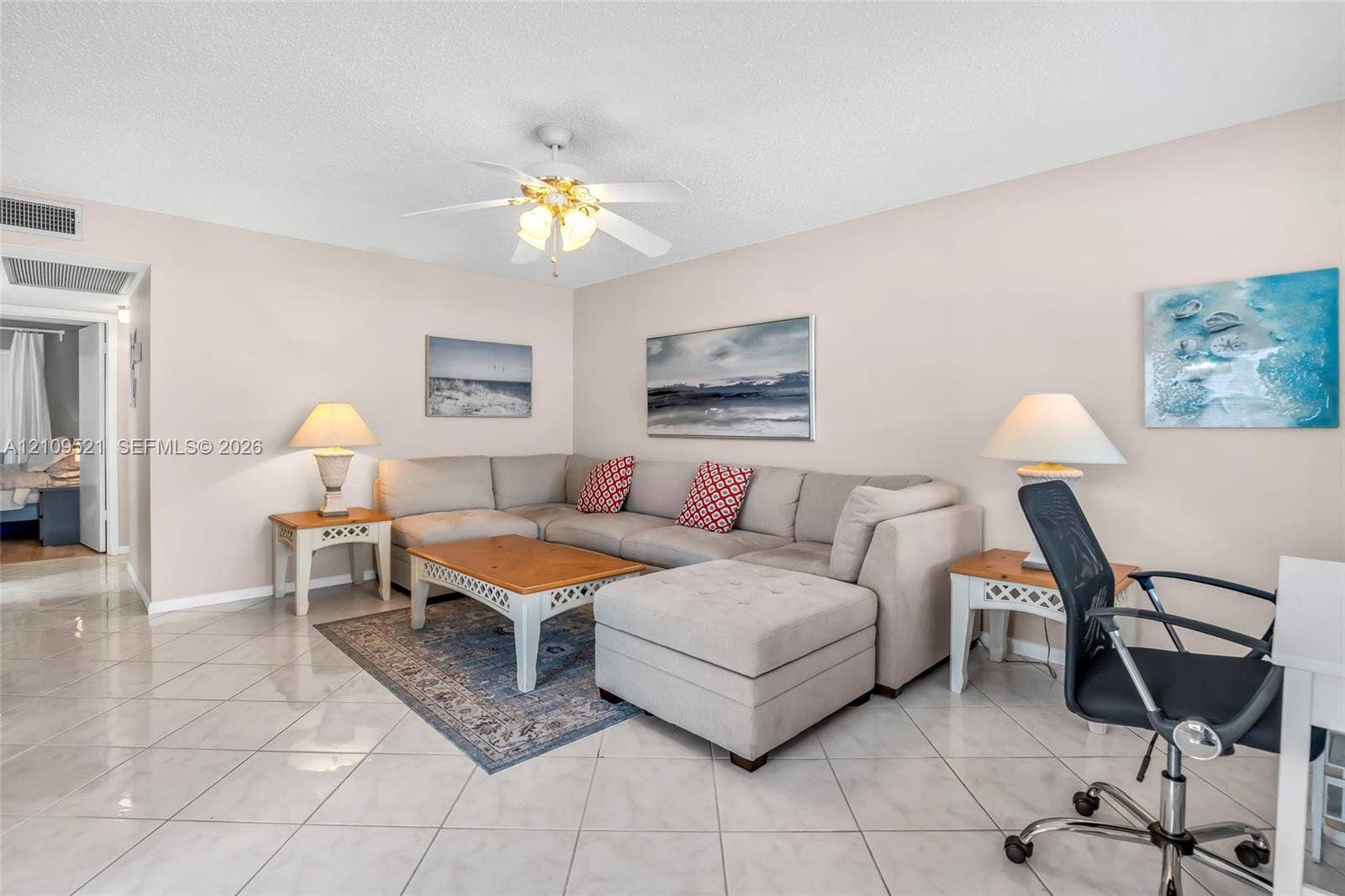 Neutral-toned interior featuring large-format tile flooring and a ceiling-mounted fan with integrated light fixture