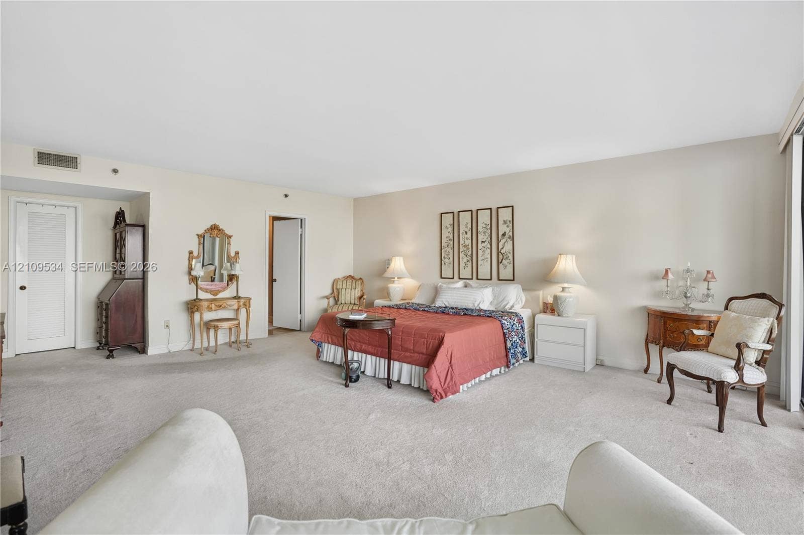 Spacious room featuring wall-to-wall carpeting, neutral wall color, and sliding glass panel doors
