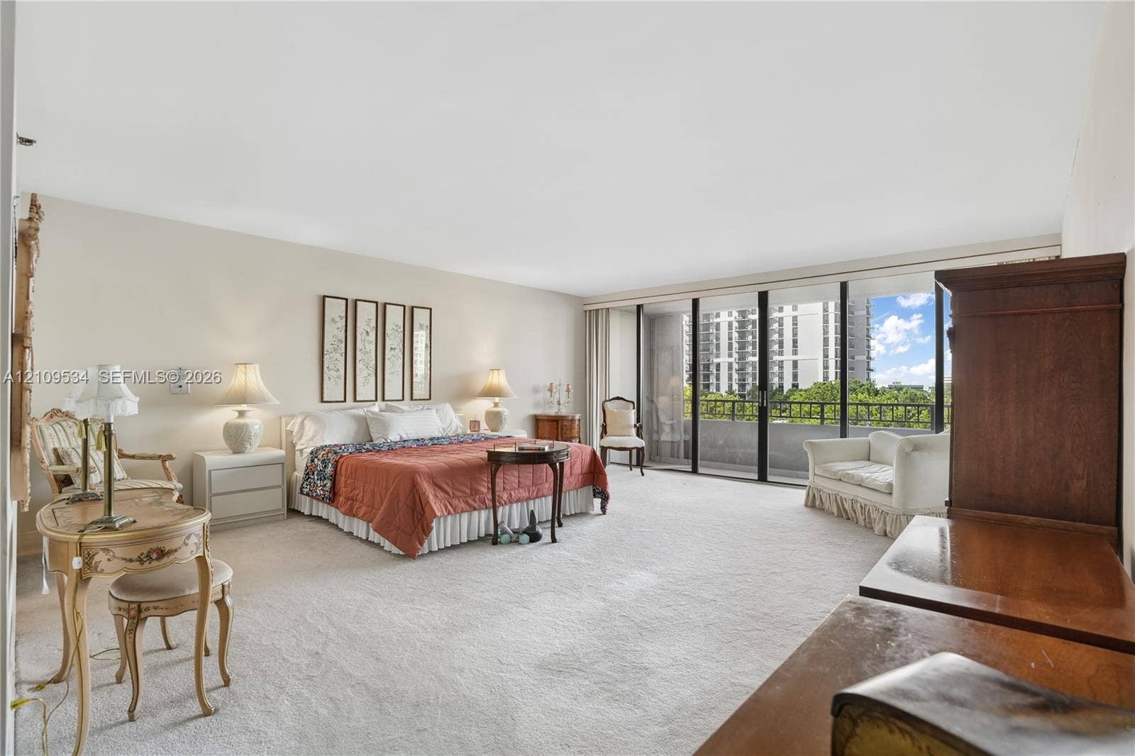 Spacious room with wall-to-wall carpeting and floor-to-ceiling glass panel doors providing access to a private balcony