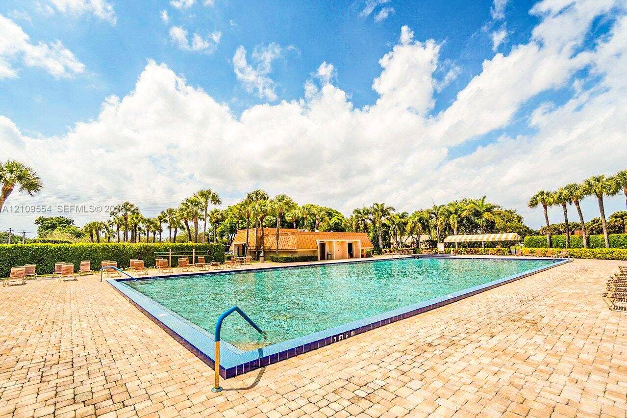 1802 18th Way, #1802, West Palm Beach, West Palm Beach, FL 33407 Rectangular swimming pool with tiled coping, surrounding paver decking, and manicured perimeter hedging