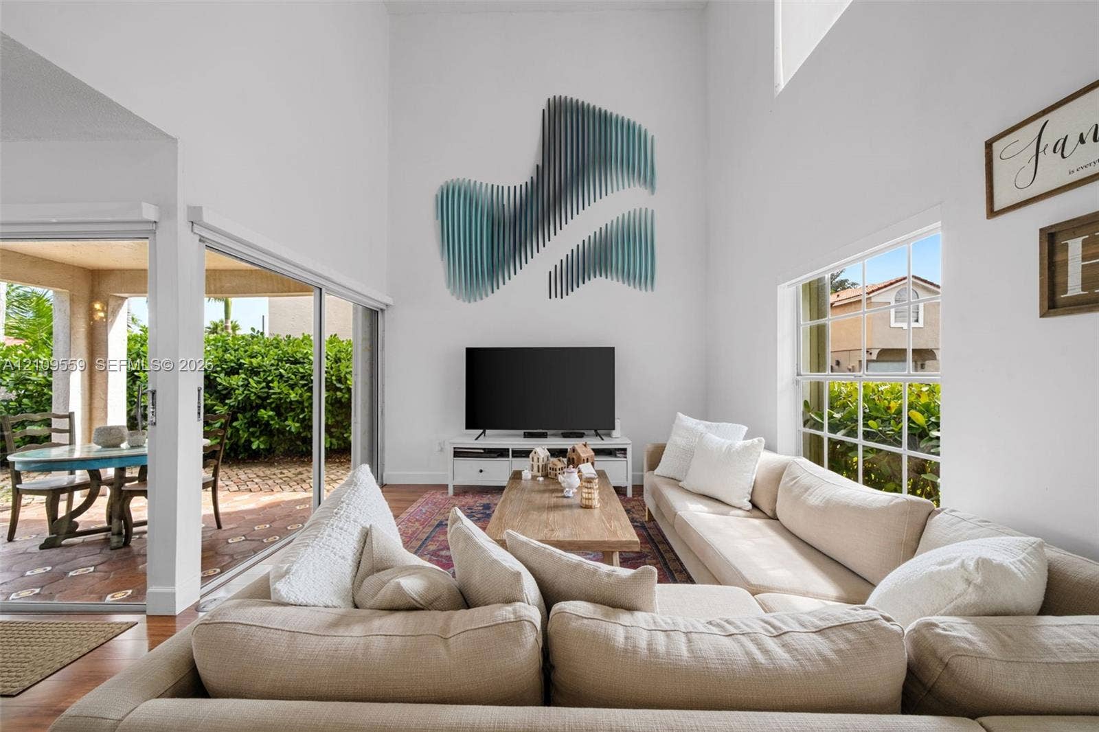 10217 NW 56th Street, Doral, FL 33178 Vaulted ceilings, expansive multi-panel sliding glass doors, and grid-pane windows providing natural light