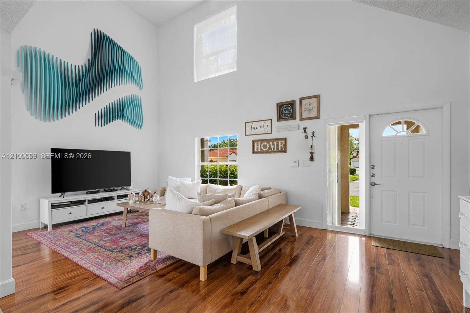 10217 NW 56th Street, Doral, FL 33178 Vaulted ceilings, wood-finish flooring, high-reaching windows, and a panelled front door with an arched glass insert