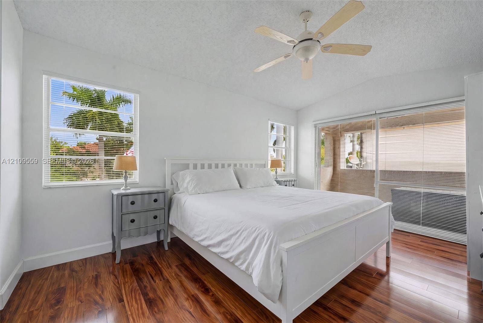 10217 NW 56th Street, Doral, FL 33178 Wood-finish flooring, vaulted ceilings with a center fan, and large windows with horizontal blinds