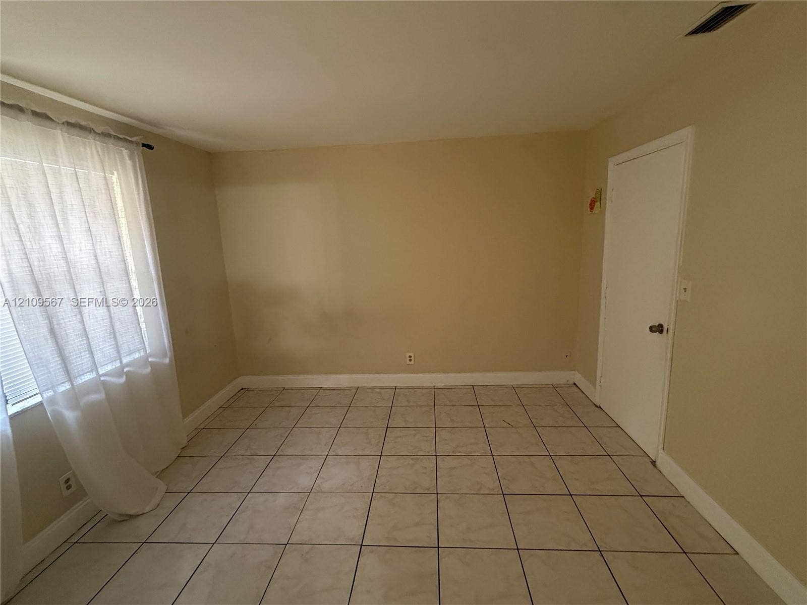 1132 NE 5th Avenue, #1, Fort Lauderdale, Fort Lauderdale, FL 33304 Interior room featuring neutral wall paint, large-format tile flooring, a window with fixed hardware, and a single-panel interior door