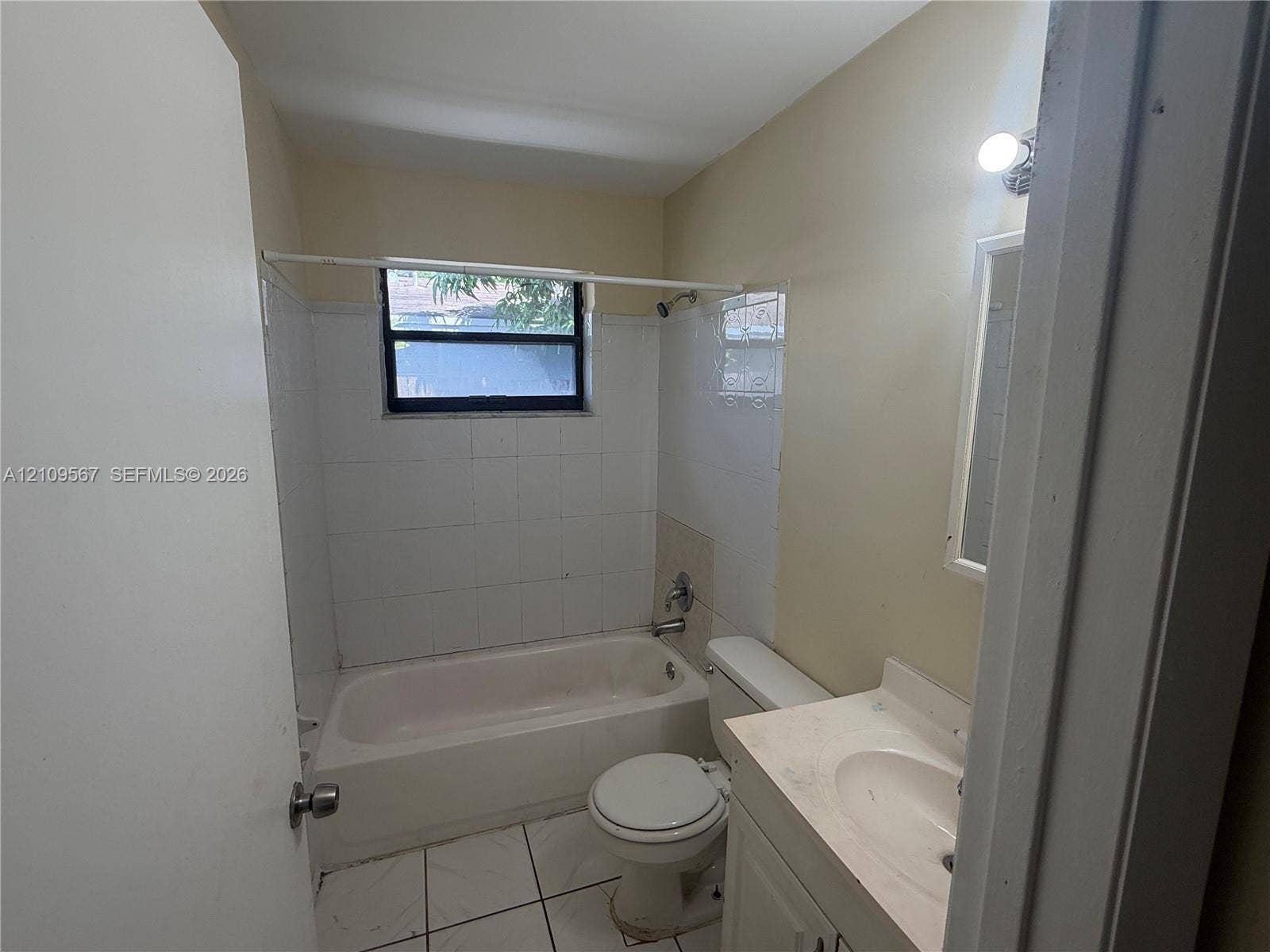 1132 NE 5th Avenue, #1, Fort Lauderdale, Fort Lauderdale, FL 33304 Bathroom featuring a white vanity with integrated sink, porcelain tile flooring, white wall-surround tub, and wall-mounted light fixture