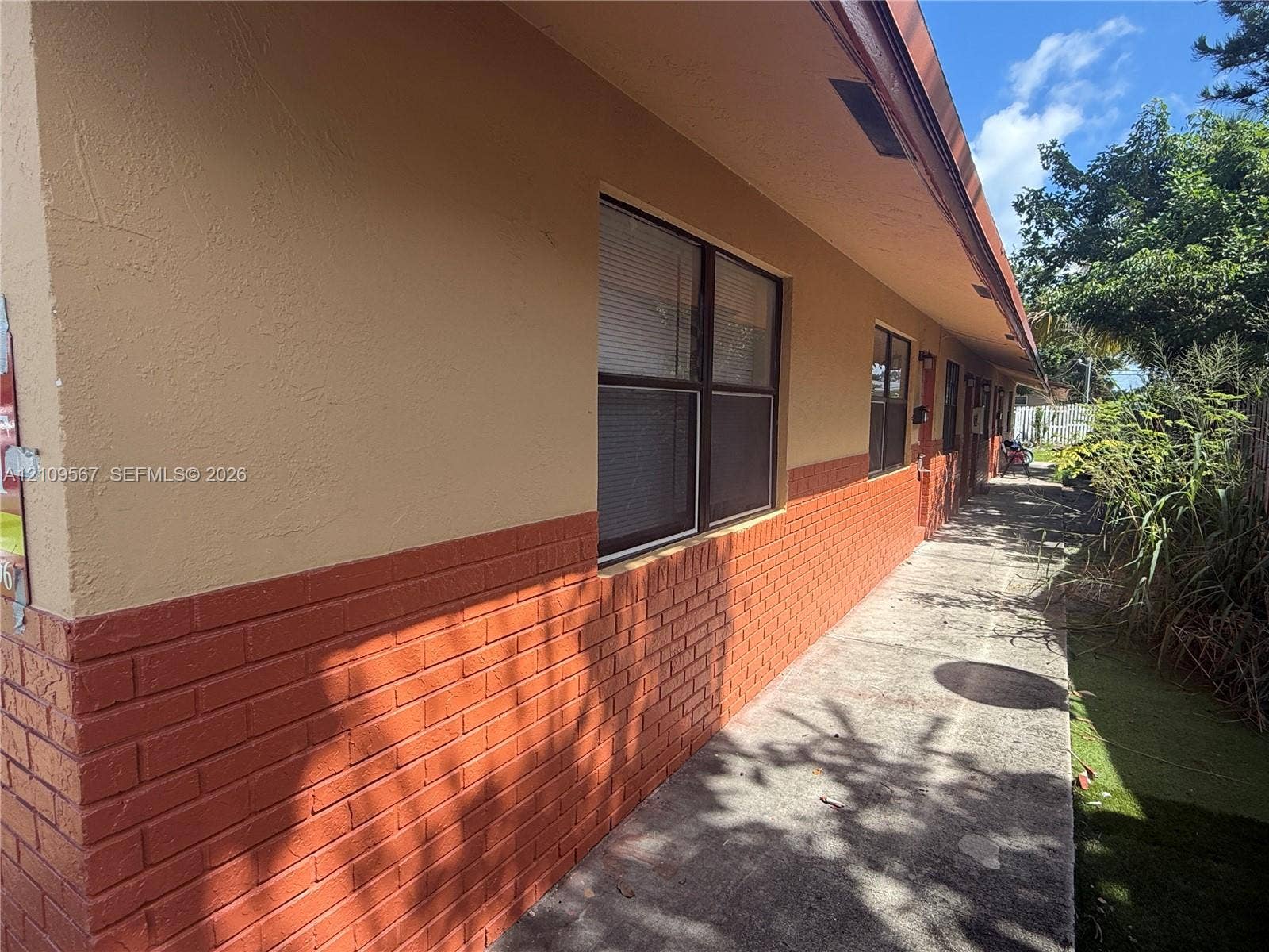 1132 NE 5th Avenue, #1, Fort Lauderdale, Fort Lauderdale, FL 33304 Exterior facade featuring a combination of textured stucco and brick masonry, concrete walkway, and window groupings with dark frames