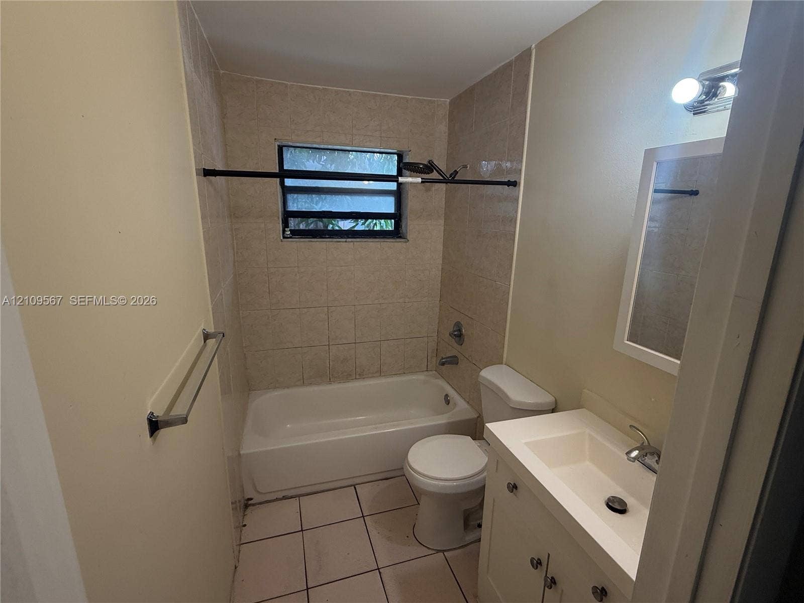 1132 NE 5th Avenue, #1, Fort Lauderdale, Fort Lauderdale, FL 33304 Full bathroom featuring a tub-shower combination with tiled surround, light-colored vanity with integrated sink, rectangular tile flooring, and wall-mounted vanity lighting