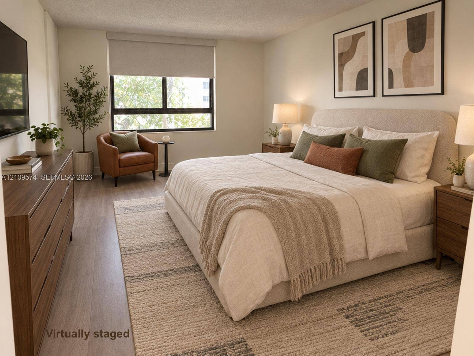 Staged. Neutral wall palette featuring vinyl wood-finish flooring and a large picture window with a retractable roller shade