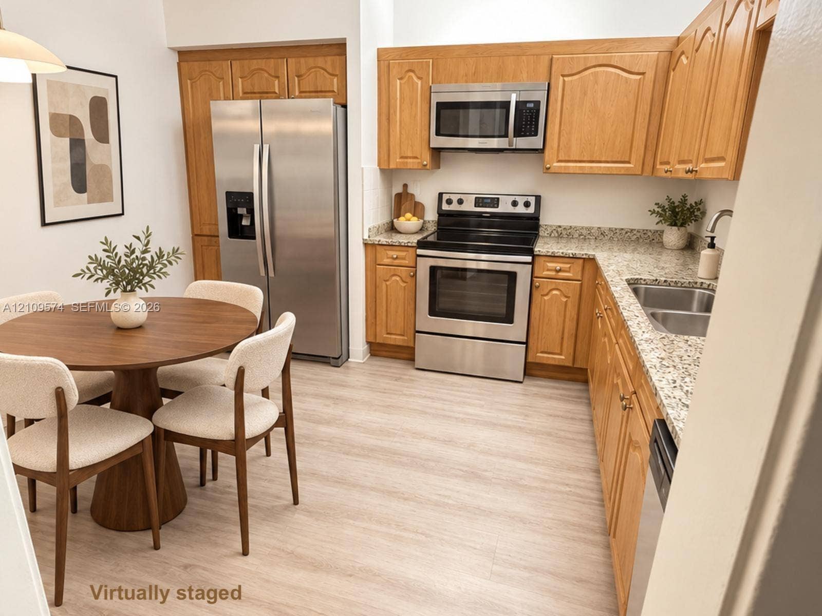 Kitchen featuring wood cabinetry, stone-finish countertops, stainless steel appliances, and light-tone wood-finish flooring