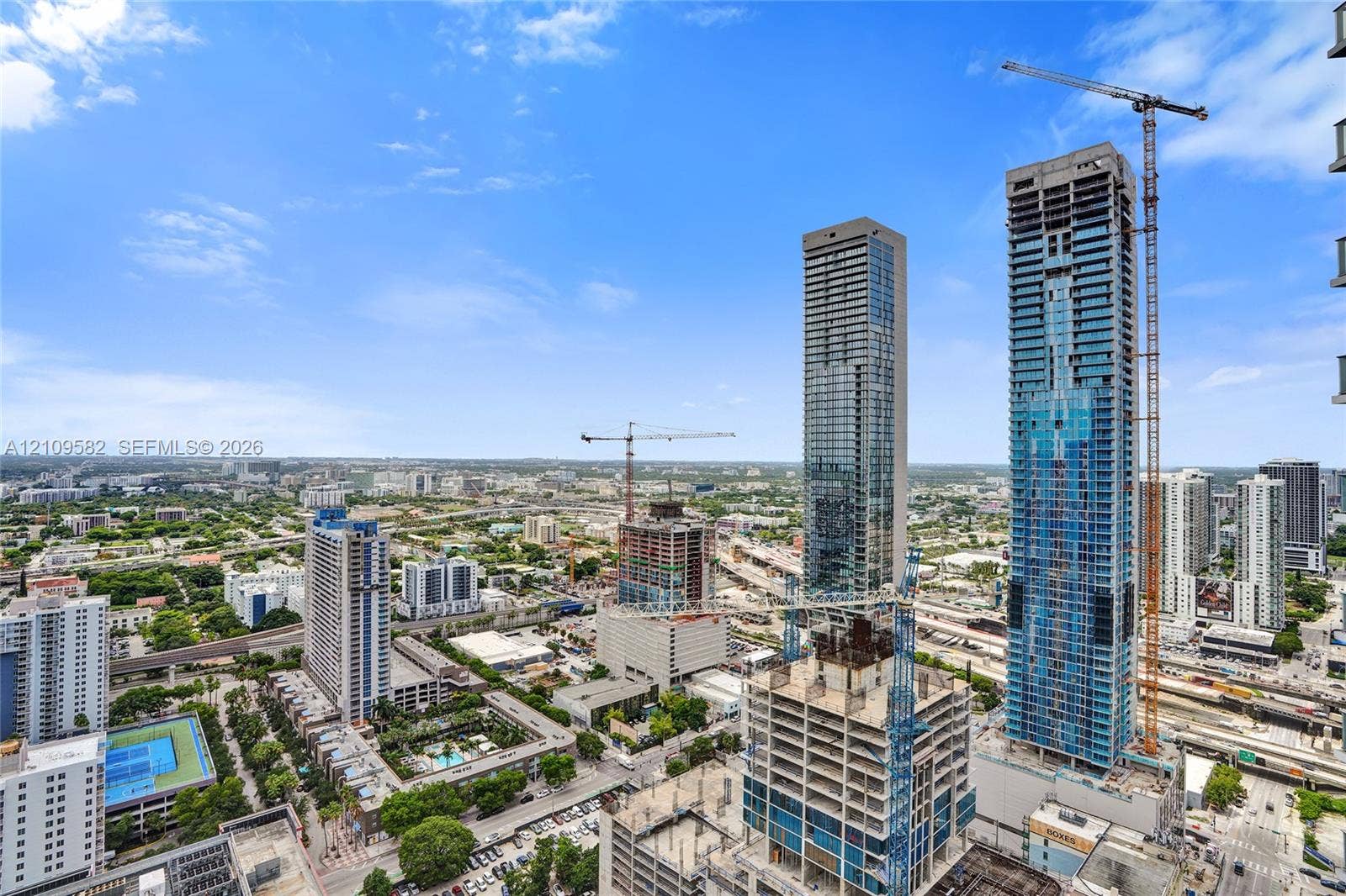 Elevated cityscape perspective featuring high-rise glass-clad towers and surrounding metropolitan infrastructure