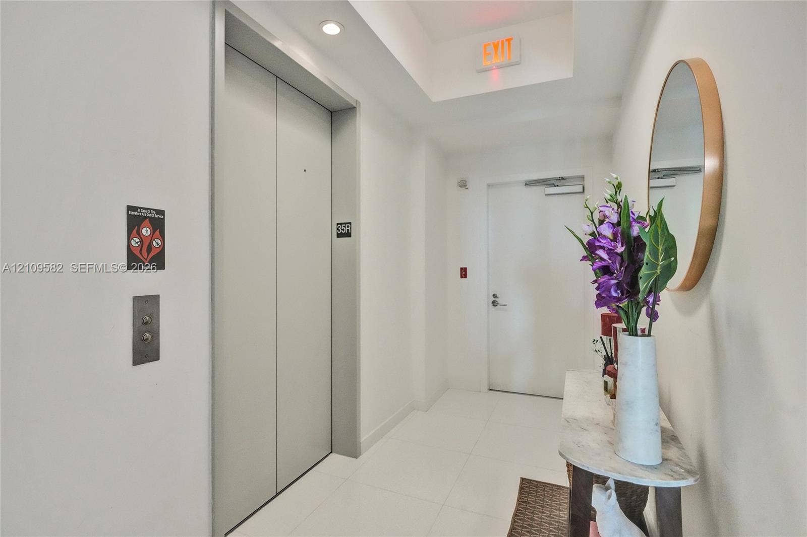 Elevator, foyer, featuring metallic doors, recessed lighting, and white tile flooring