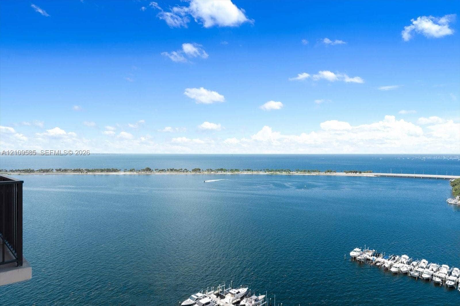 1865 Brickell Avenue, #APHVII, Miami, FL 33129 Elevated balcony featuring metal railings with a panoramic water horizon, shoreline, and deep-water marina