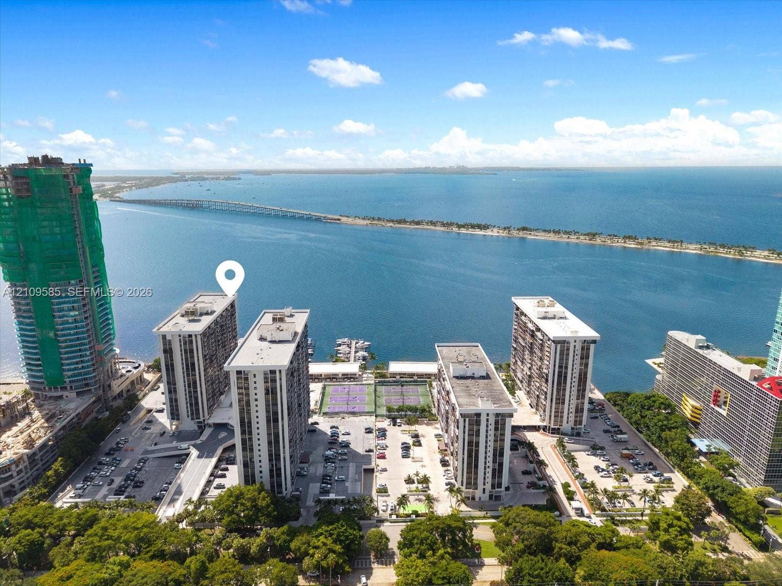1865 Brickell Avenue, #APHVII, Miami, FL 33129 Waterfront high-rise complex featuring multiple tennis courts, a private dock, and expansive surface parking